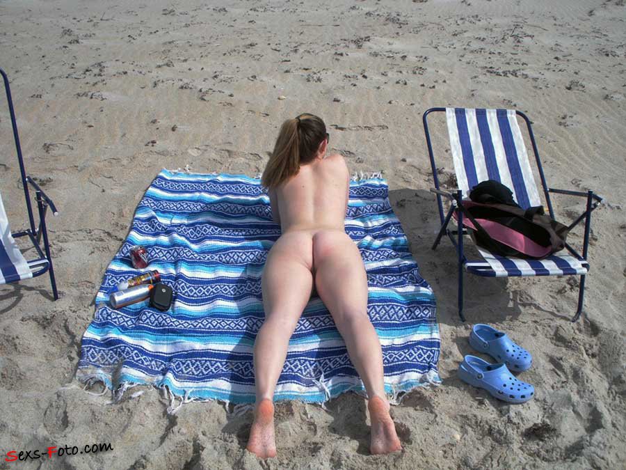 Нудистка позирует на пляже