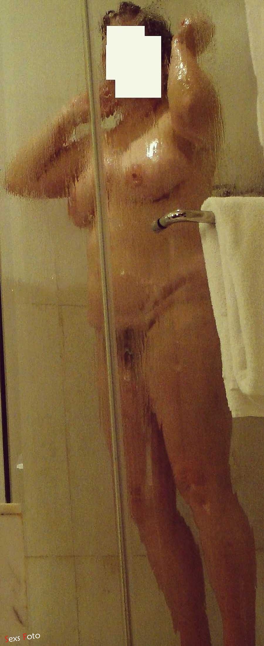 Голая женщина принимает душ на корточках